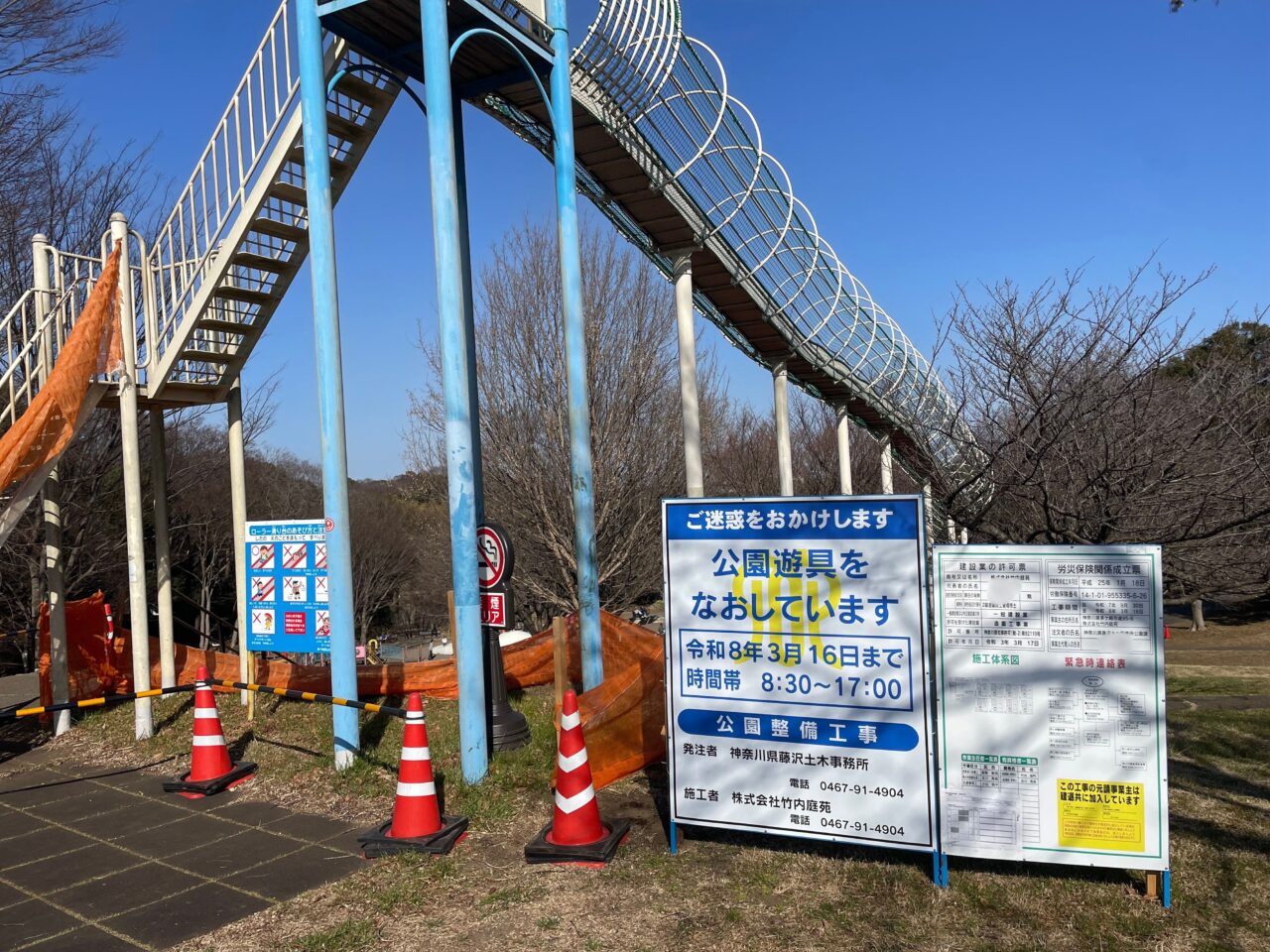 ローラー滑り台の付近に工事の掲示板が立っている様子