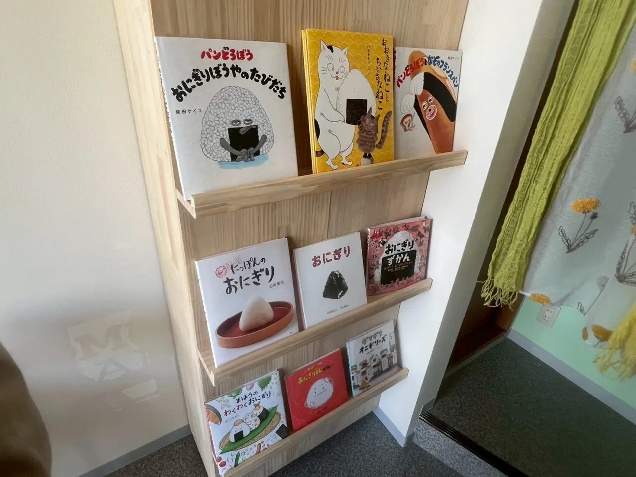 おむすびに関する絵本が並ぶおむすびまるしゅの店内棚