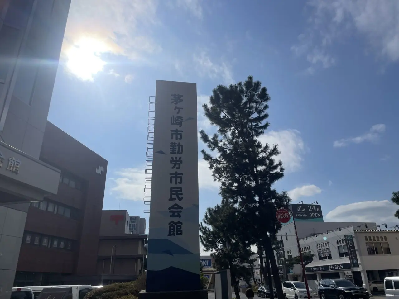 青空の下に立つ茅ヶ崎市勤労市民会館の案内サイン