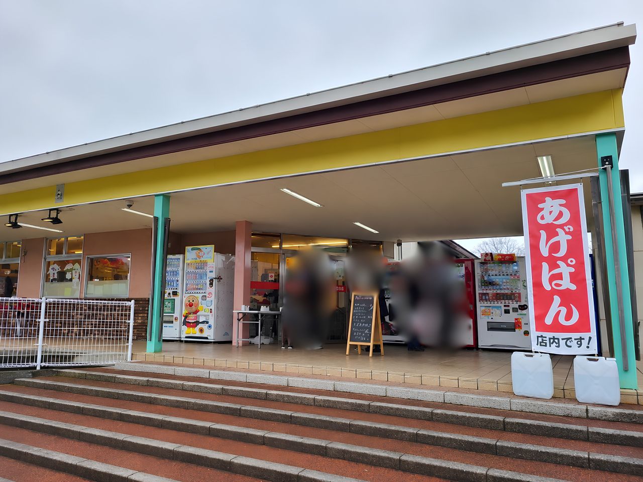 人気のあげぱんを販売する店舗の外観。入口には「あげぱん」ののぼり旗が掲げられ、多くの利用客でにぎわう様子