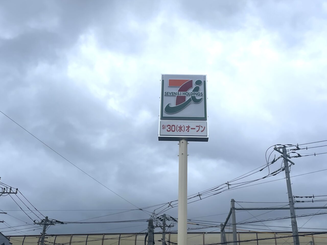 道路側の看板に掲示されたセブン-イレブンの9月30日オープン案内